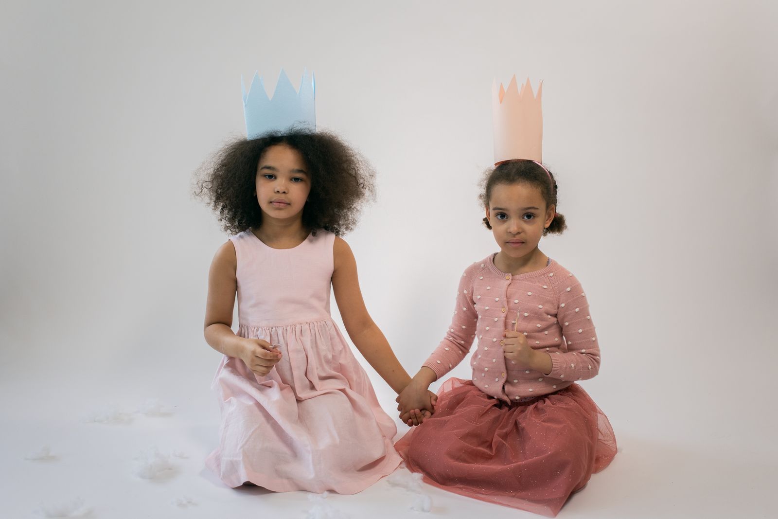 Prințese cu cununi făcute manual, în rochii roz, zâmbind
